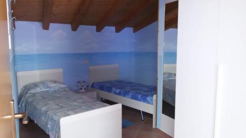 una piccola camera con due letti e uno specchio di Mansarda Ariel a Limone sul Garda