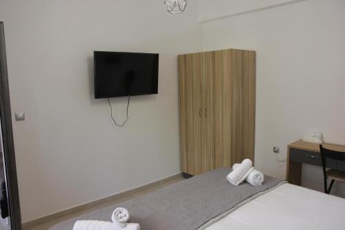 a bedroom with a bed with a flat screen tv on the wall at Platoni Elite in Ialyssos