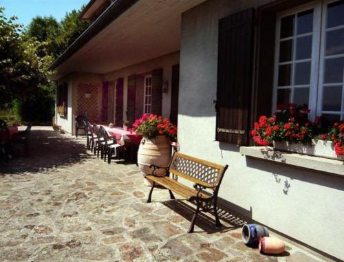 a bench sitting on the side of a building with flowers at Chambres d'Hôtes Baudelys in Pont-de-Larn