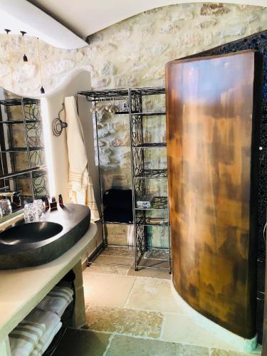 a bathroom with a sink and a shower at La Maison du Passage - Chambres - Suites premium, Spa, Piscine et Restaurant in Martignargues