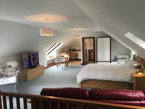 a bedroom with a bed and a couch in a room at The Suite at Scarbuie in Ballater