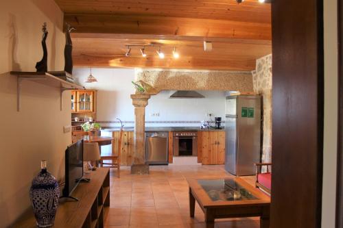 a large kitchen with a table and a counter top at A Casiña de Pedra in Noalla