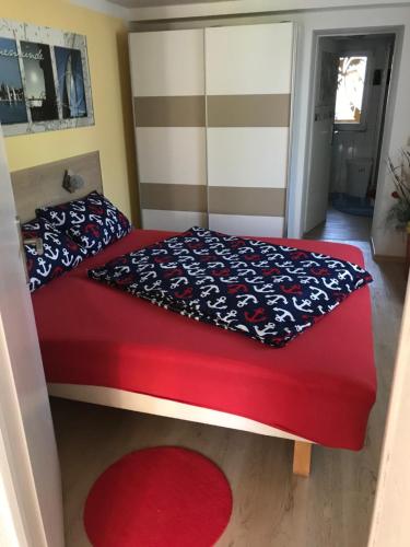 1 dormitorio con cama roja y alfombra roja en Kompass, en Rostock
