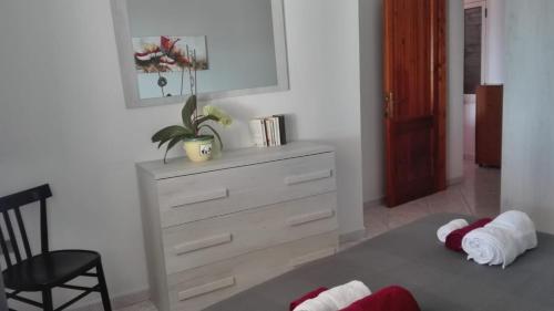 a bedroom with a dresser and a chair with towels at Casa Dolores in Baunei