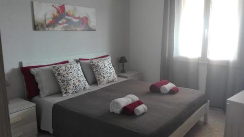 two stuffed animals sitting on a bed in a bedroom at Casa Dolores in Baunei