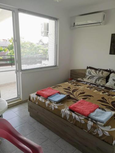 a bedroom with a bed with two pillows on it at Guestrooms Stoyanovi in Chernomorets
