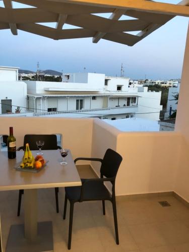 a table and chairs on a balcony with a view at 3 Wishes in Naxos Chora