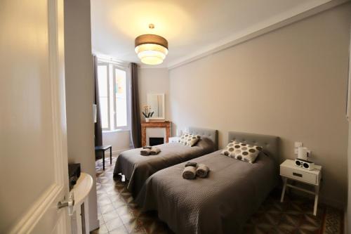 カンヌにある70m2 Apartment - La Roseraieのベッドルーム1室(ベッド2台付)、壁に照明が備わります。
