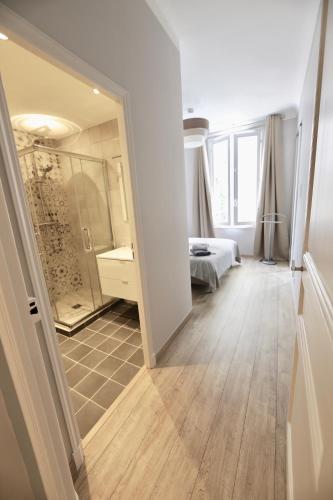 une chambre avec un lit et une salle de bain avec un miroir dans l'établissement 70m2 Apartment - La Roseraie, à Cannes
