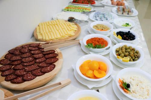 a table with meat and bowls of different types of food at Hotel Old Konak in Skopje