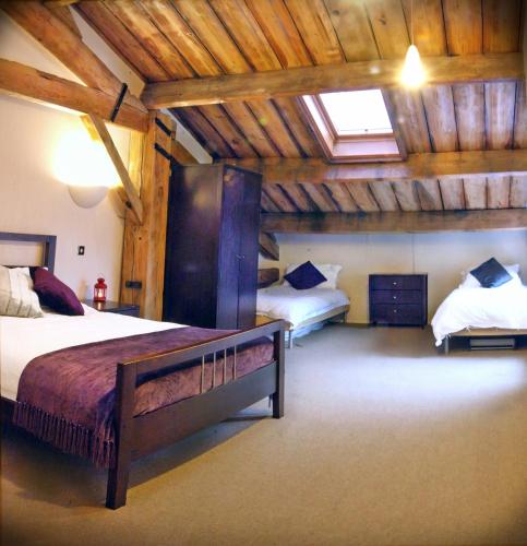 a bedroom with two beds in a room with wooden ceilings at Apartment 3, Warehouse K in London