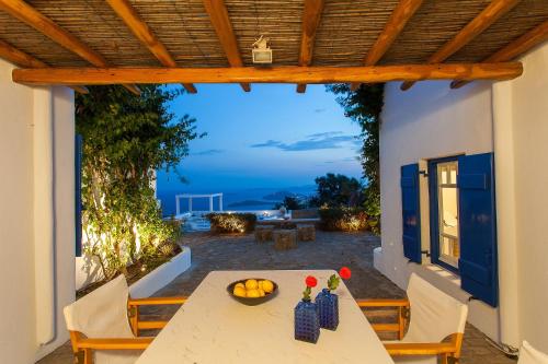 uma mesa com uma tigela de fruta no pátio em Amazing Villa 6bed in Agios Lazaros Mykonos em Psarou