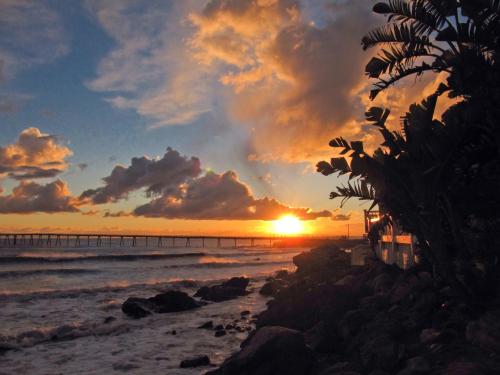 a sunset on the beach with a pier at Cliff House Inn in Carpinteria