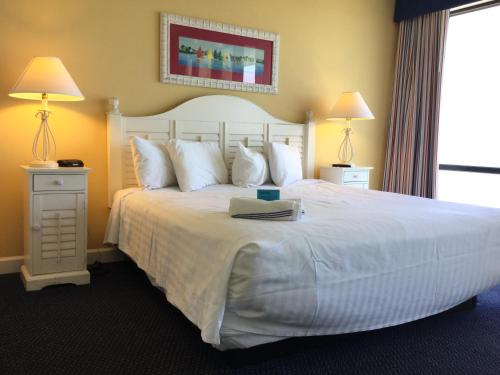 A bed or beds in a room at Peppertree Ocean Club Resorts