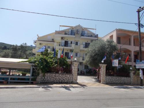 a large building with flags in front of it at Pansion Filoxenia Apartments & Studios in Tsoukalades