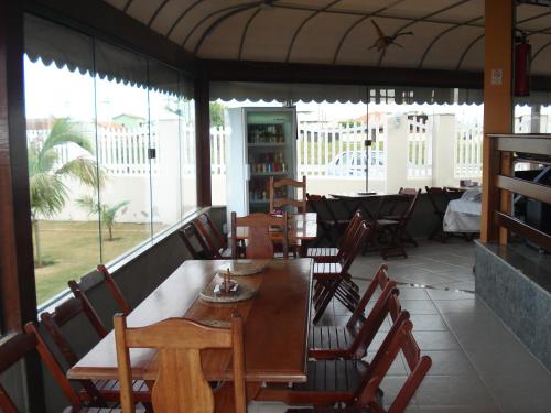 a dining room with a table and chairs and windows at Villaggio dos Ventos in Arraial do Cabo