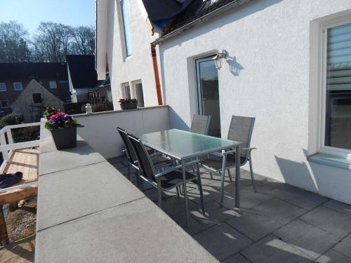 eine Terrasse mit einem Tisch und Stühlen auf dem Balkon in der Unterkunft Ferienhaus Königsberg Haus 2 in Scharbeutz