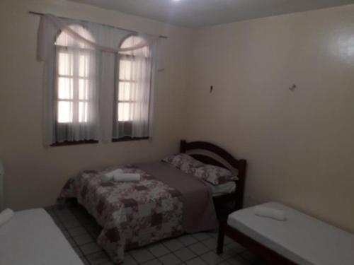 ein kleines Schlafzimmer mit einem Bett und einem Fenster in der Unterkunft Pousada Santa Bárbara in Maruda