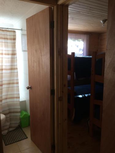eine offene Tür zu einem Zimmer mit einem Bett in der Unterkunft Cabañas Los Cuatro Robles in Las Trancas