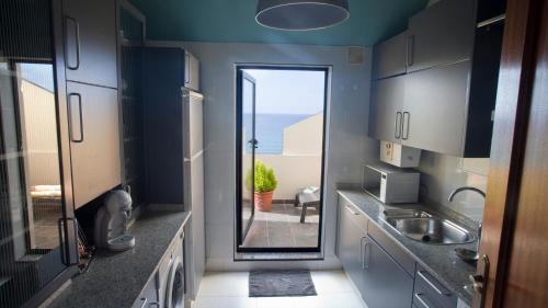 a kitchen with a door leading to a balcony at Apartamento Malpica Area Grande in Malpica