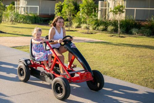 a woman and a little girl riding a toy tricycle at Ingenia Holidays Rivershore in Maroochydore