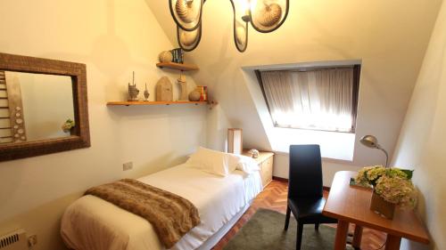 1 dormitorio con cama, escritorio y espejo en Apartamento Malpica Area Grande, en Malpica de Bergantiños