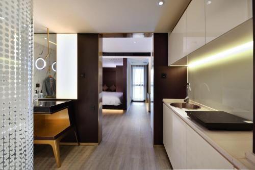 a kitchen with a sink and a bed in a room at CitiGO Hotel Nanshan Shenzhen in Shenzhen