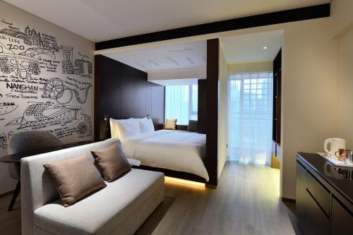 a bedroom with a bed and a couch in a room at CitiGO Hotel Nanshan Shenzhen in Shenzhen