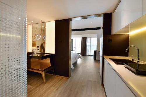 a bathroom with a sink and a bedroom at CitiGO Hotel Nanshan Shenzhen in Shenzhen