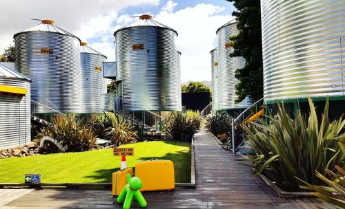 a green toy in front of three large silos at SiloStay in Little River