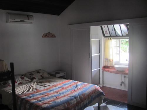um quarto com uma cama, uma janela e um lavatório em Pousada ECO em Corupá