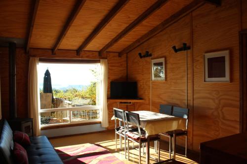 a dining room with a table and a window at Cabañas Mas Ke Miel in Lago Ranco
