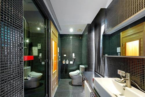 a bathroom with a sink and a toilet and green tiles at Hotel Double One in Taipei
