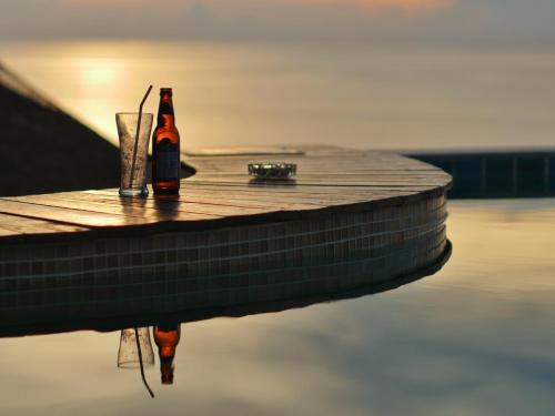 a bottle of beer and a glass sitting on a dock at DD Hut Koh Tao in Koh Tao