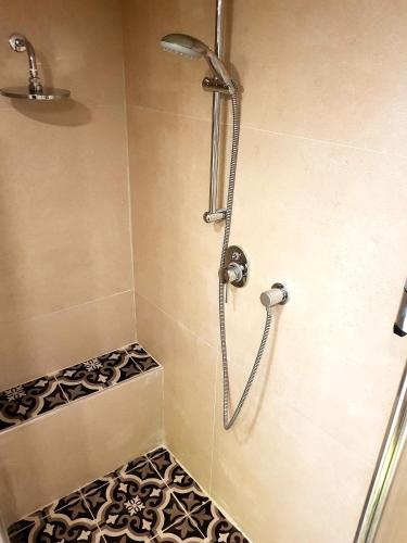 a shower in a bathroom with a tile floor at Neot Golf, Ziv's Place in Caesarea