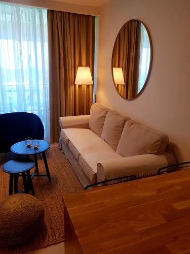 a living room with a couch and a mirror at Neot Golf, Ziv's Place in Caesarea