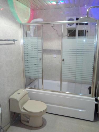 a bathroom with a toilet and a glass shower at Afaq Al Raha in Khamis Mushayt
