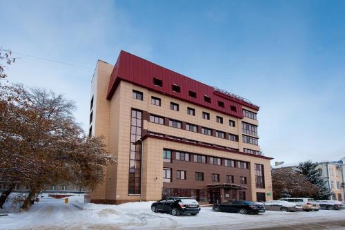 un edificio con dos coches estacionados frente a él en Hotel Ulitka, en Barnaul