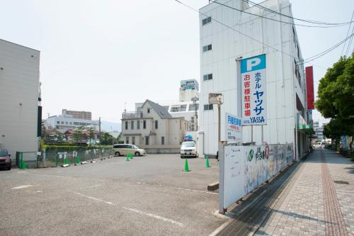 a parking lot with a parking sign next to a building at Hotel Yassa in Mihara