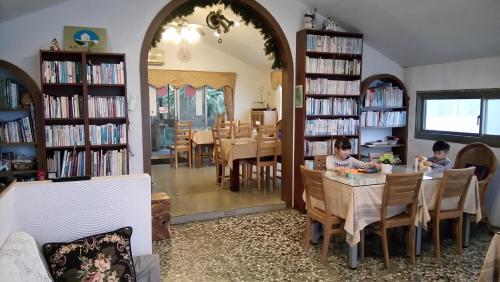 dwoje dzieci siedzących przy stole w bibliotece w obiekcie Levite Villa w mieście Jiufen