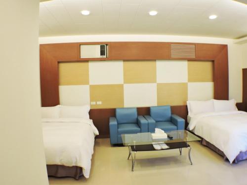 a hotel room with two beds and a blue couch at Natural Residence B&B in Taian