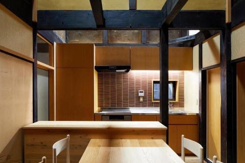 a kitchen with a wooden table and some chairs at Marukyo Gakurin-an in Kyoto