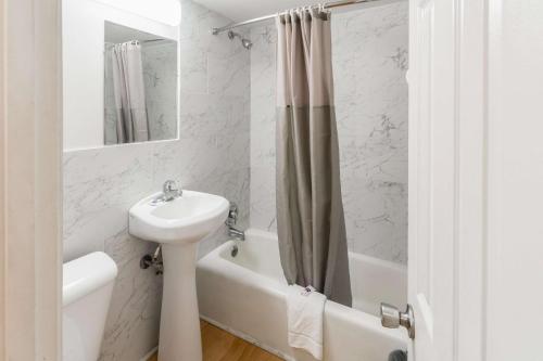 a white bathroom with a sink and a toilet and a tub at Flamingo Motel in Rio Grande