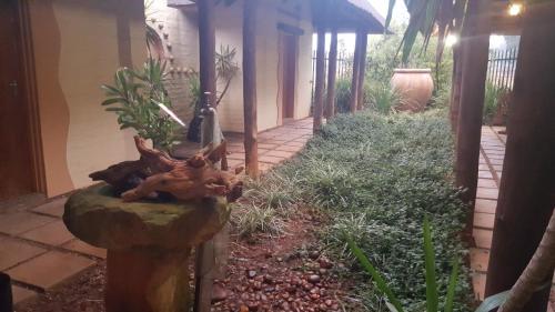 a garden with a statue of a deer laying on a rock at African Silhouette Guesthouse in Benoni