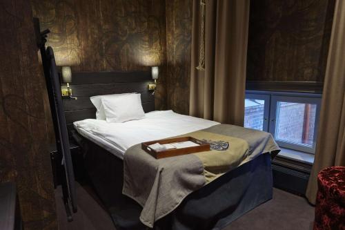 a bedroom with a bed with a tray on it at Stora Hotellet; BW Premier Collection in Umeå