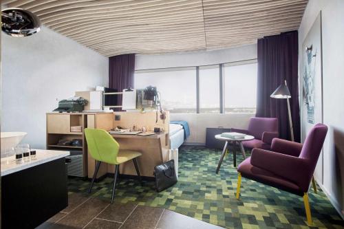 a hotel room with a bed and a desk and chairs at U&Me; BW Signature Collection in Umeå
