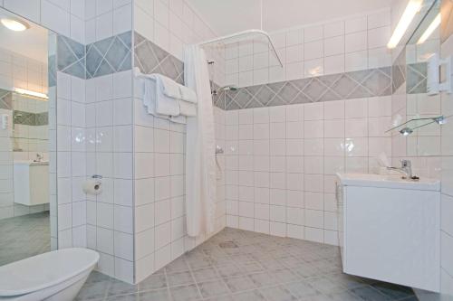 a bathroom with a toilet and a sink and a shower at Chesterfield Hotel in Trondheim