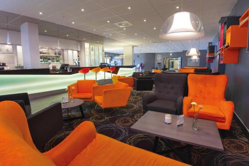 a lobby with orange chairs and a waiting room at Best Western Leto Arena in Dal