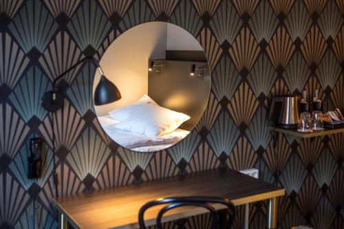 a bedroom with a bed and a mirror on a wall at Hotell Boras, BW Signature Collection in Borås
