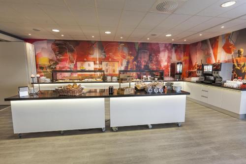 a kitchen with a counter with food on it at Best Western Leto Arena in Dal